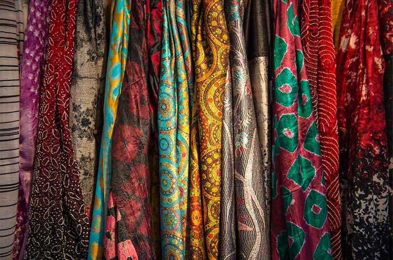 Lots of colorful, patterned scarves on display. 