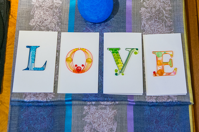four greeting cards spell out LOVE